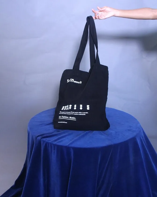 Black St O'Donnell tote bag displayed on a blue velvet table